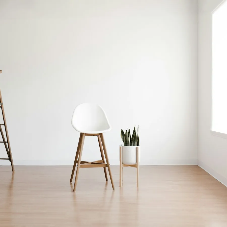 A wooden step ladder, stool and plant in a freshly painted room.