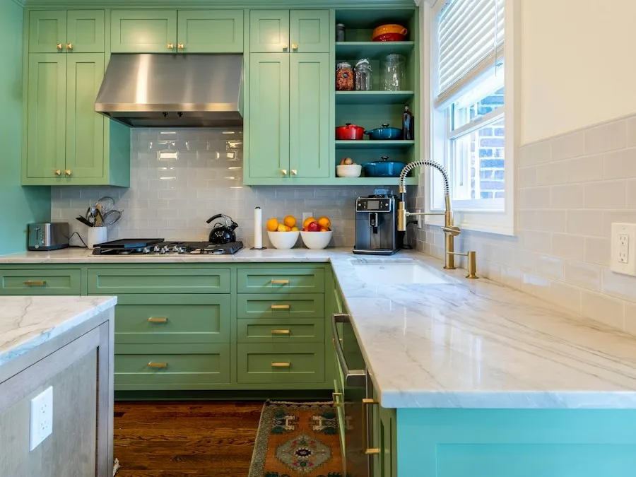 A kitchen with recently repainted green cabinets and pale counters.