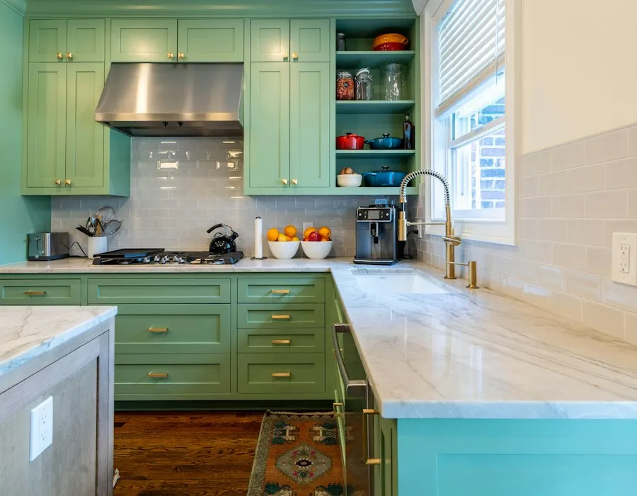 A kitchen with recently repainted green cabinets and pale counters.