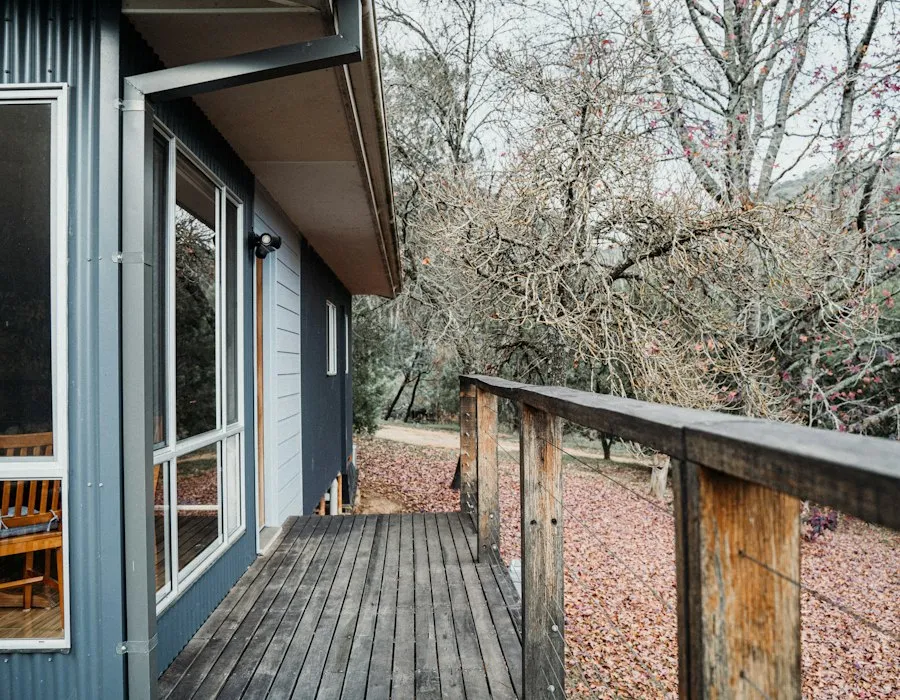 A wooden deck with a table and chairs, boards freshly sealed.