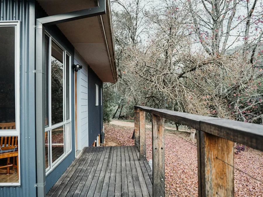 A wooden deck with a table and chairs, boards freshly sealed.
